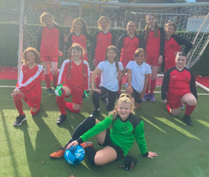 a girls football team wearing red kit